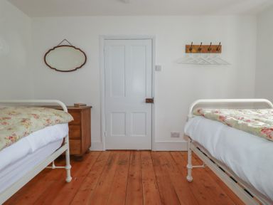 A bedroom with two beds and a door at 84 Fore Street