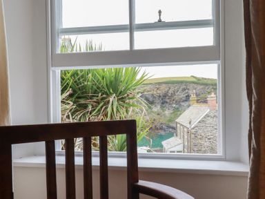 A window with a view of a plant and buildings at 84 Fore Street 