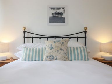 A bed with pillows and lamps at 84 Fore Street