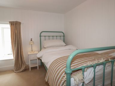 A bedroom with a bed and side table at 84 Fore Street in 