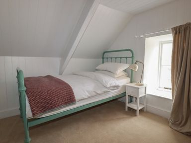 A bedroom with a bed and nightstand at 84 Fore Street