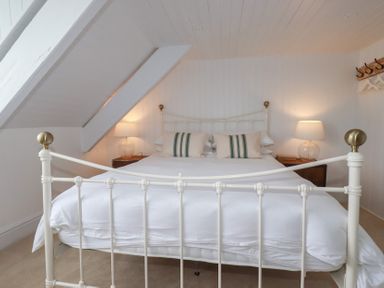 A bedroom with a bed and nightstands at 84 Fore Street