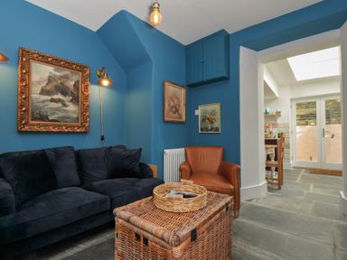 A snug with a sofa and armchair at 84 Fore Street in Port Isaac
