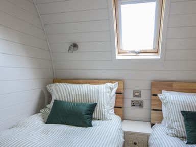 A bedroom with two beds striped bedding and a skylight window at Maple in Wootton Fitzpaine near Charmouth