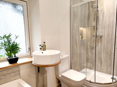A bathroom with a toilet sink and a glass shower enclosure at Cranford House in Keswick