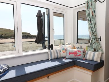 A sunroom with a sea view and cushions at 4 Burgh Island Causeway Bigbury