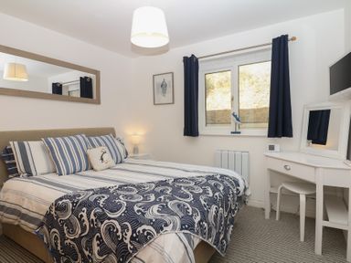 A bedroom with a bed and a dressing table at 4 Burgh Island Causeway in Bigbury