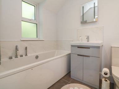 A bathroom with a bathtub sink with cabinet mirror and toilet at Linden View in Combe Martin