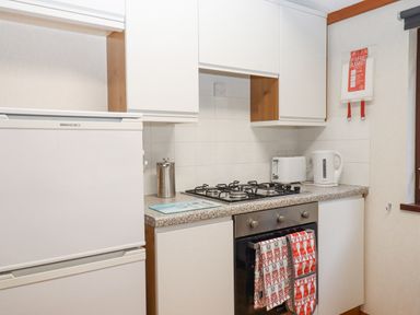 A kitchen with a refrigerator stove oven toaster kettle and fire blanket at Teign River Retreat in Drewsteignton near Moretonhampstead