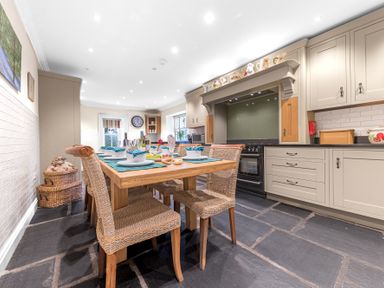 A kitchen with a wooden dining table and woven chairs at Gate House in Coniston