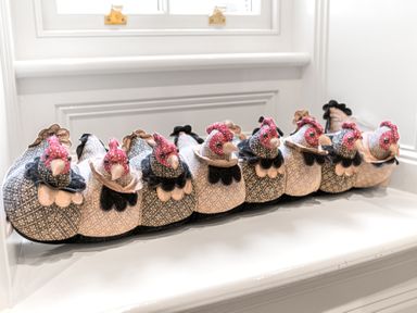 A row of decorative fabric chickens on a windowsill at Gate House in Coniston