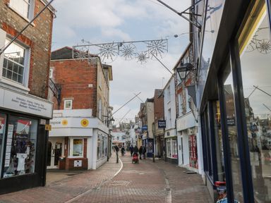 A pedestrian street with shops and people walking on a cloudy day at 15 Rosewood Great Thorness near Northwood Isle Of Wight