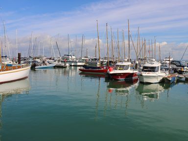 A harbor with multiple boats docked on calm water at 15 Rosewood in Great Thorness near Northwood Isle Of Wight