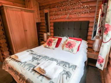 A bedroom with a double bed pillows wardrobe and bedside tables at 10 Water's Edge in Morpeth near Felton