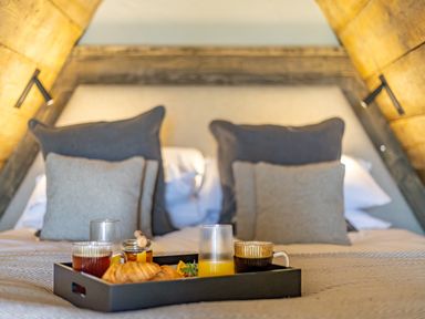 A bed with pillows and a tray holding croissants juice coffee and jam at The Tri-Pod in Pantcefn near Llanarth