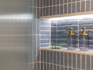 A tiled shower niche with soap dispensers and a soap dish at The Tri-Pod in Pantcefn near Llanarth