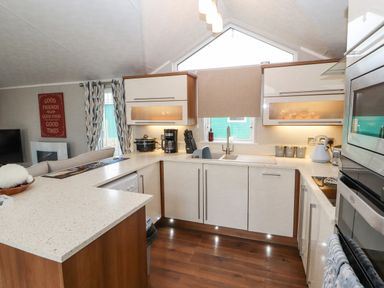 A kitchen with white countertops appliances and kitchenware at No.7 Skiddaw View in Moota near Aspatria