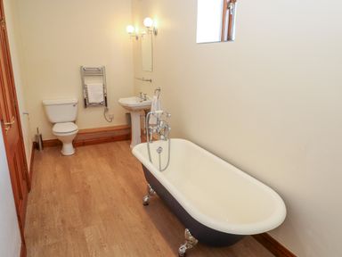 A bathroom with a clawfoot bathtub toilet sink and towel rack at The Granary in Prussia Cove near Rosudgeon