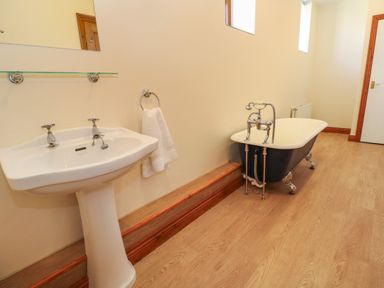 A bathroom with a pedestal sink and a clawfoot bathtub at The Granary in Prussia Cove near Rosudgeon