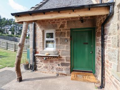 An entrance with a green door and welcome mat at Bruno's Bothy Middleton near Belford