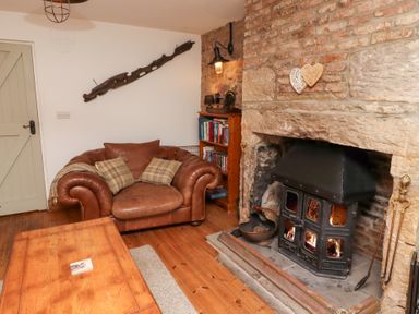 A living room with a sofa and fireplace at Bruno's Bothy Middleton near Belford