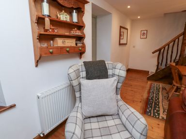 A living room with a shelf and a chair at Bruno's Bothy Middleton near Belford