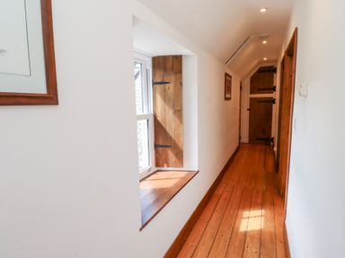 A hallway with a window and wooden door at Bruno's Bothy Middleton near Belford