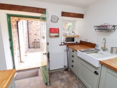 A kitchen with a sink and microwave at Bruno's Bothy Middleton near Belford