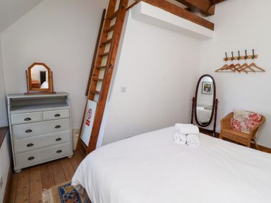 A bedroom with a bed and dresser at Bruno's Bothy Middleton near Belford
