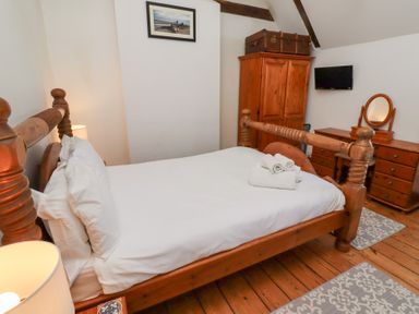 A bedroom with a bed and dresser at Bruno's Bothy Middleton near Belford