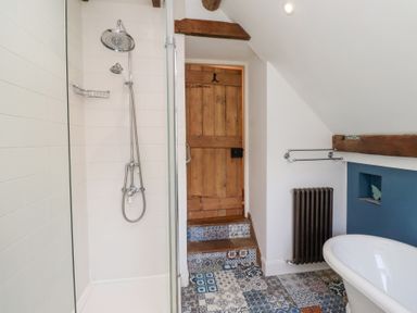 A bathroom with a shower and bathtub at Bruno's Bothy Middleton near Belford
