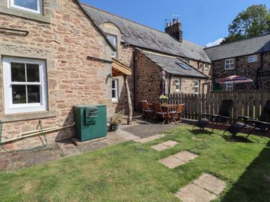 An outdoor area with seating and garden space at Bruno's Bothy Middleton near Belford