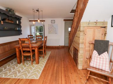 A dining room with a table and chairs at Kits Cottage Middleton near Belford