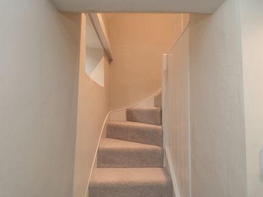 A narrow carpeted staircase with beige walls at York House in Thornton Dale