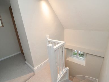 A stairway with white railing and a small window at York House in Thornton Dale