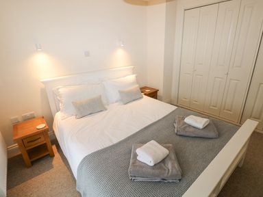 A bedroom with a double bed and bedside tables at The Old Boathouse in Trefin near St Davids