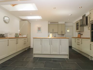 A kitchen with cabinets island and appliances at 21 Passage Street formerly Panacea in Fowey