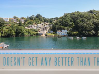 A waterfront view with houses on a hill and boats on the water at 21 Passage Street formerly Panacea in Fowey