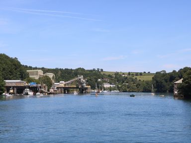 A river with boats and industrial buildings along the shore at 21 Passage Street formerly Panacea in Fowey