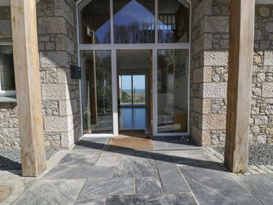 Stone entrance with glass door and wooden posts at Lower Mellan Barn in Coverack