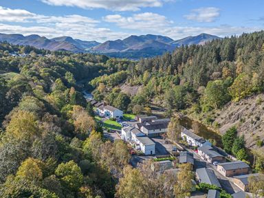A residential area with houses and trees near a river at Apartment 1 in Keswick