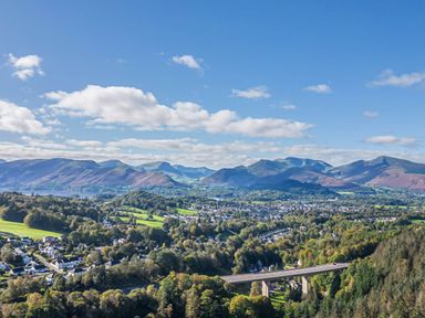 A landscape view featuring mountains, a bridge, and a town in the countryside at Apartment 2 in Keswick