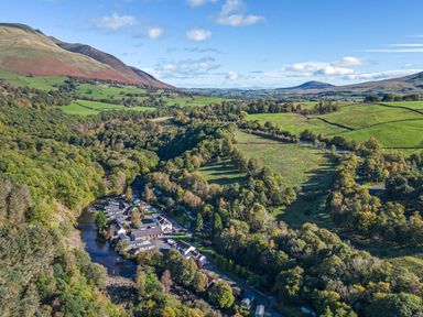 A valley with houses and a river surrounded by trees and mountains at Apartment 2 in Keswick