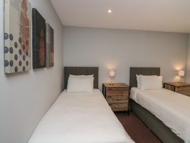 A bedroom with two single beds bedside tables and lamps at Apartment 6 in Keswick