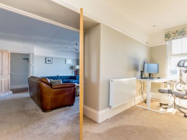 A living room with sofas and a separate office area with a desk and computer at Tre Lowen in Port Isaac