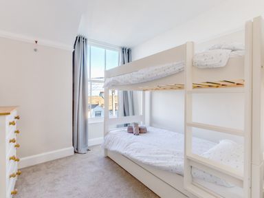 A bedroom with a bunk bed next to a window and a chest of drawers at Tre Lowen in Port Isaac