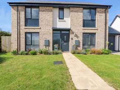 A front view of a two-story house with a paved walkway and garden at Cobalt in St Eval near Mawgan Porth