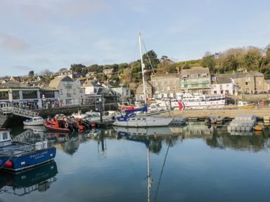 A harbor with boats docked and buildings in the background at Cobalt in St Eval near Mawgan Porth