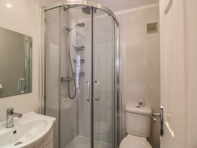 A bathroom with a corner shower enclosure a sink with a faucet and a toilet at Squirrels Nook Waterside Wood 19 White Cross Bay near Windermere