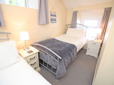 A bedroom with two single beds bedside tables and lamps at Hafan Cottage in Beddgelert